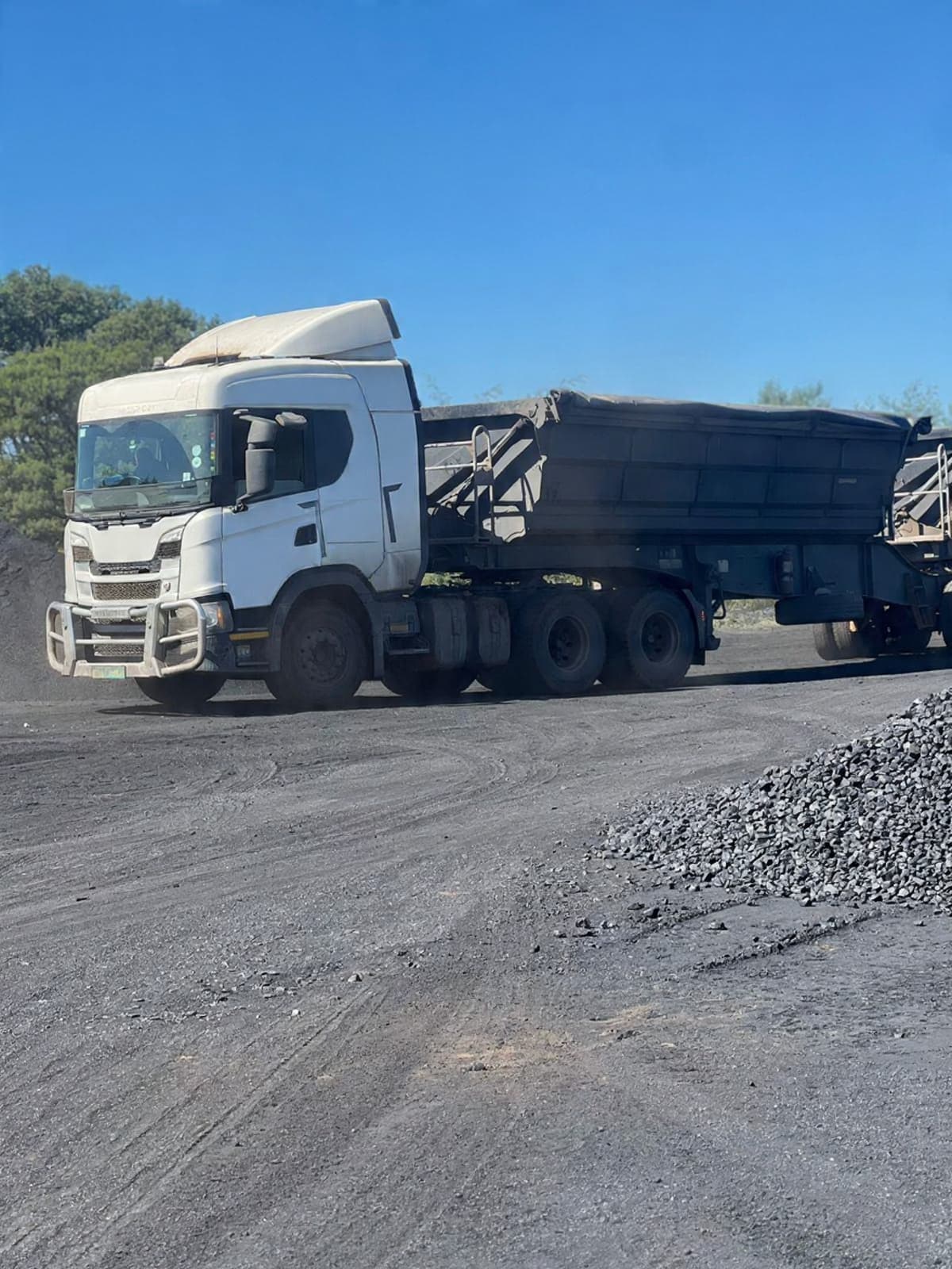 JUSTLIONNE heavy-duty bulk transport — modern tractor and side-tipper trailer at a mining site
